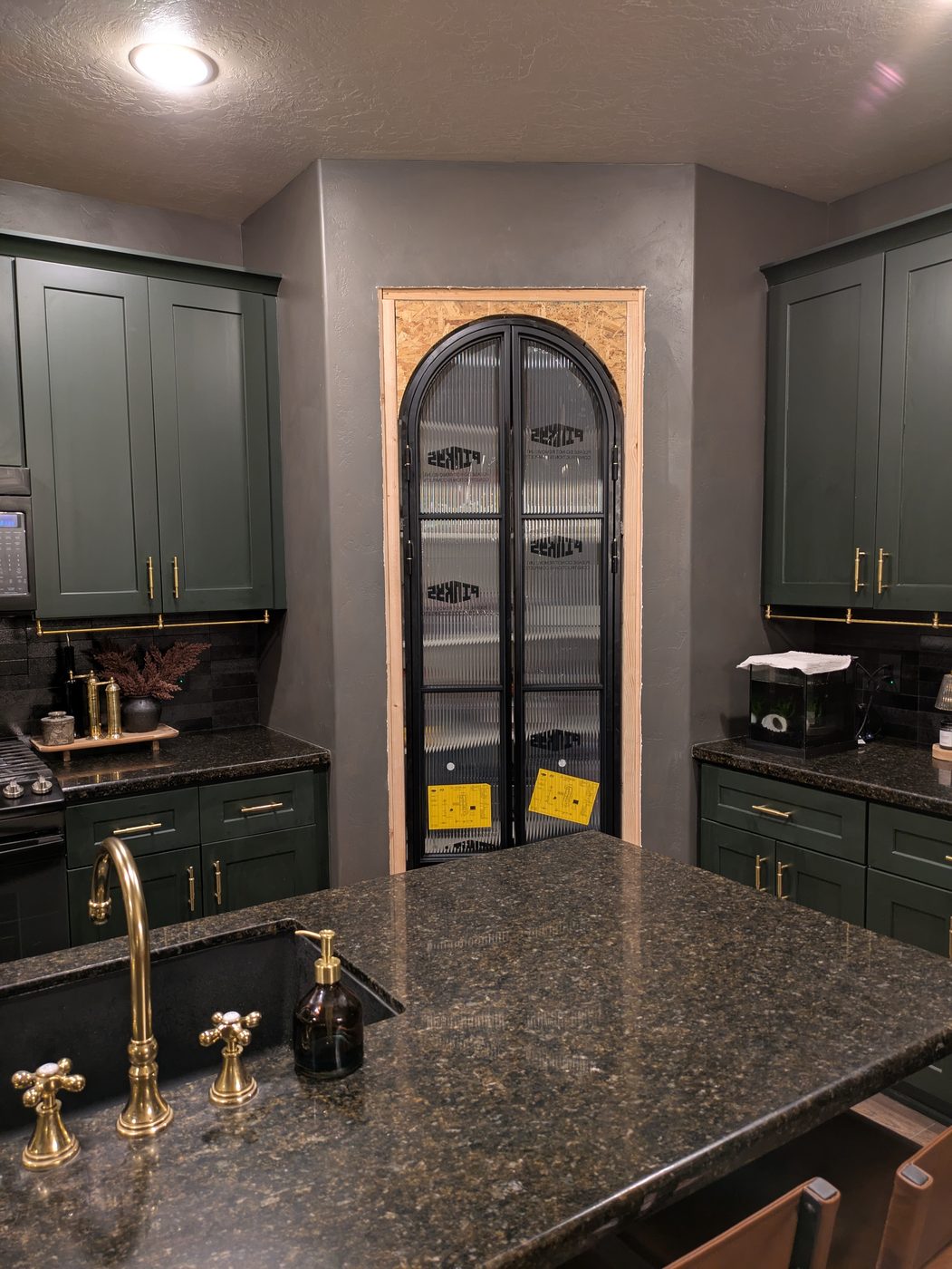 Custom arched pantry door with green cabinetry
